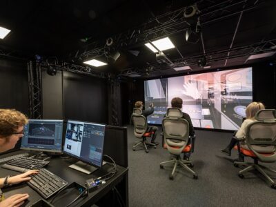 VR experience with 3 people playing in front of a big screen