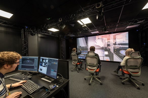 VR experience with 3 people playing in front of a big screen